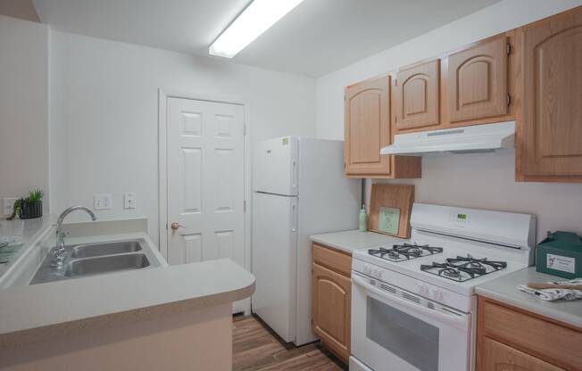 a kitchen with white appliances and wooden cabinets