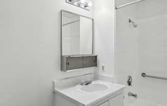 a bathroom with a sink and a mirror and a shower