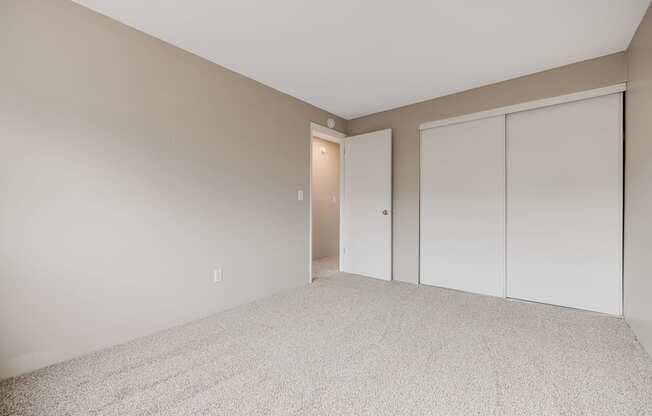 A room with a carpeted floor and a white door.
