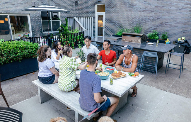 a group of people sitting around a table outside