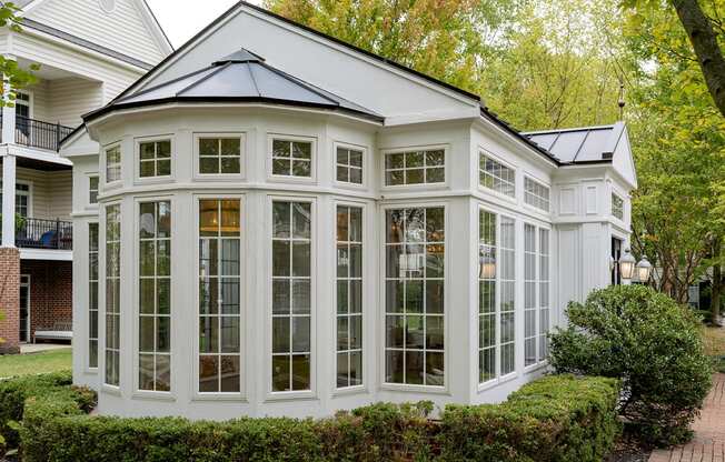 a conservatory with large windows on the side of a house