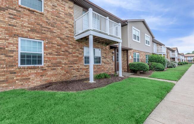 a large lawn in front of a brick building