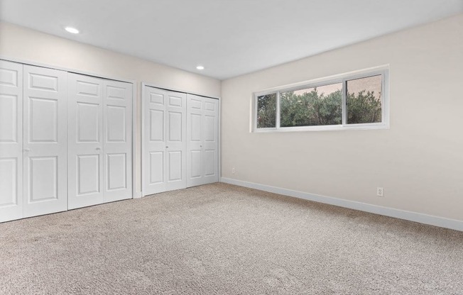 an empty room with three closets and a window