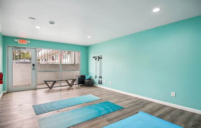 A yoga studio with a blue mat on the floor.