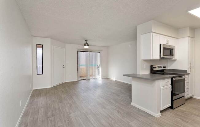 A kitchen with white cabinets and a black countertop.