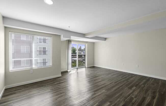 a living room with plank wood-look floors and large windows at Arabella Apartment Homes, WA 98155