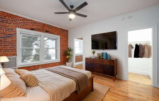 A bedroom with a brick wall and a large bed at Westmore Manor Apartments, California, 90020