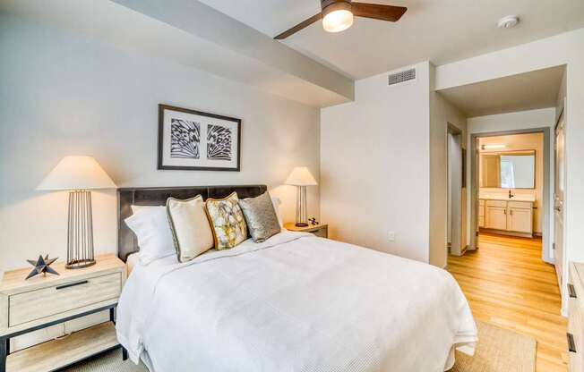 A bedroom with a large bed and a ceiling fan.