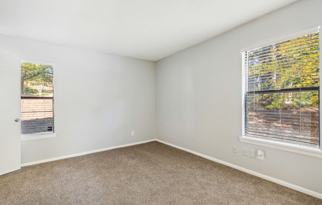 an empty room with carpet and a window