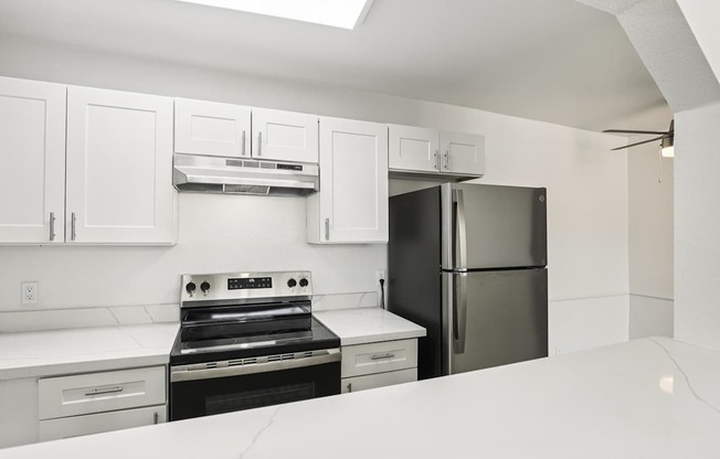 A kitchen with white cabinets and appliances.