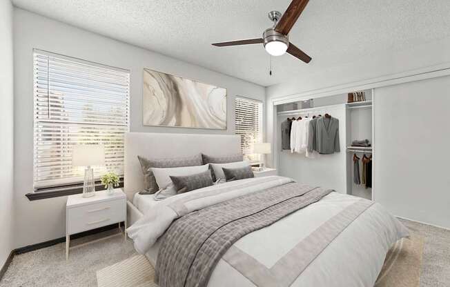 A bedroom with a large bed and a ceiling fan.