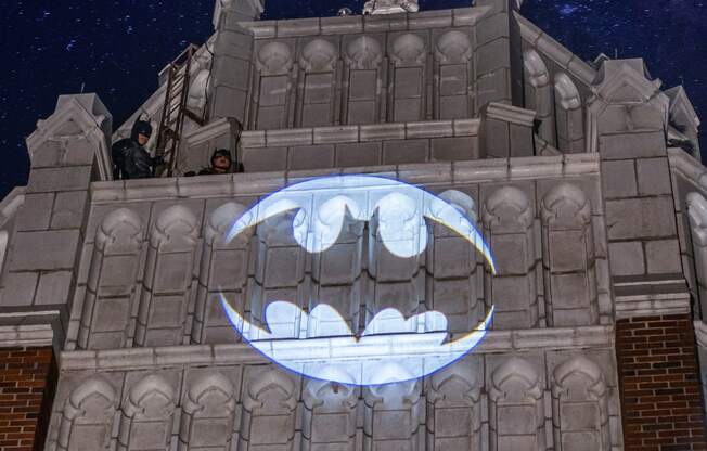 a projection of the batman logo on the side of the Equitable building