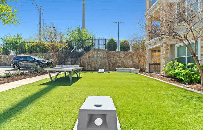 A backyard with a picnic table and a concrete block with a hole in the middle.