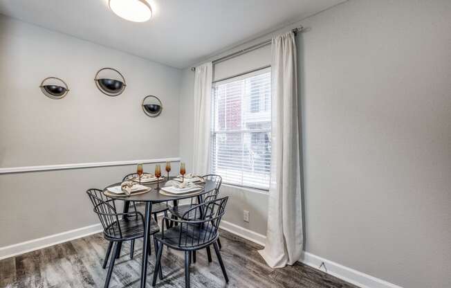 a dining room with a table and chairs and a window