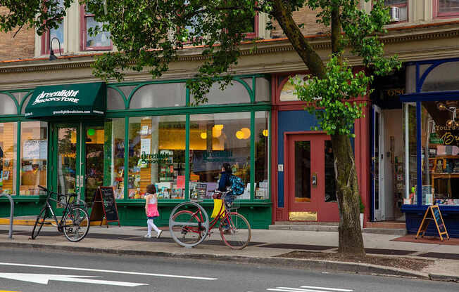 a man walking down the street with a bike at The Paxton, Brooklyn, New York