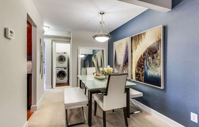 A dining room with a table and chairs.