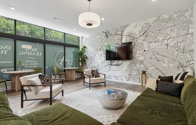 A living room with a large green couch and a map on the wall.