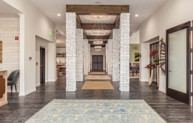 A hallway with a rug in the middle and a fireplace on the left.