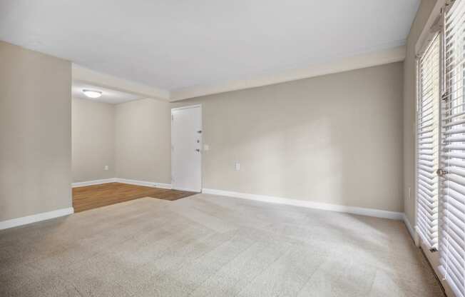 an empty living room with blinds on the window