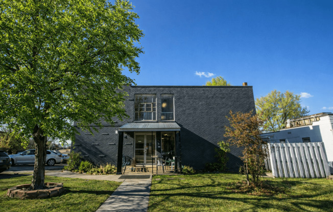 A modern house with a grey exterior and a large front yard.