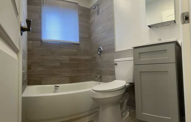 a bathroom with a toilet and a tub and a sink