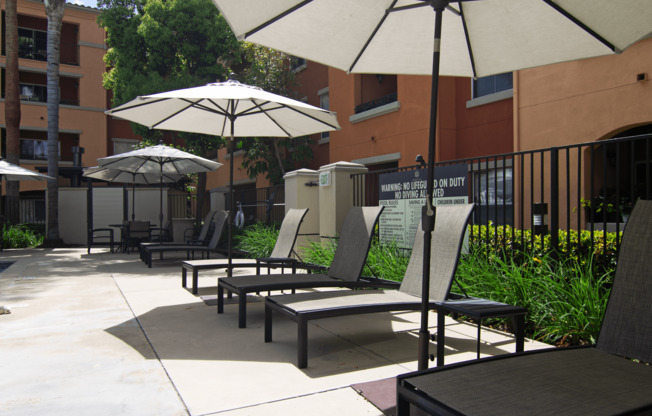A patio with chairs and umbrellas.