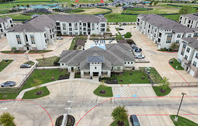 an aerial view of a neighborhood of houses with cars in a parking lot