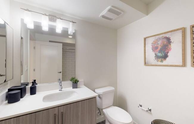 a bathroom with a sink and a toilet and a mirror at OLiVE DTLA in California 90015