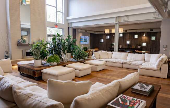 a large living room with white couches and chairs