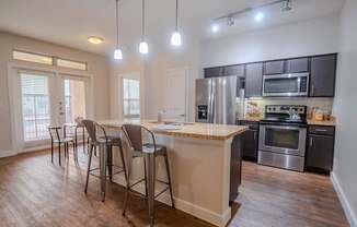 an open kitchen with a bar and a dining area with stools