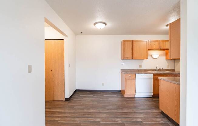 A kitchen with wooden floors and cabinets. West Fargo, ND Saddlebrook Apartments