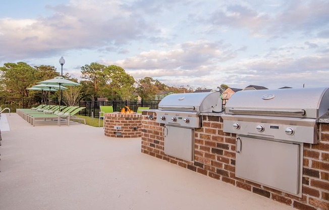 the outdoor patio has two barbecue grills and picnic tables