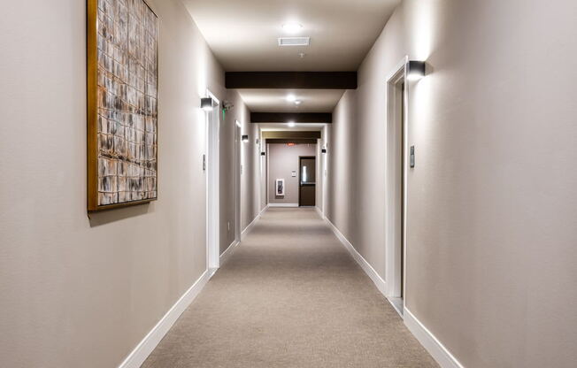 A long hallway with a painting on the wall.