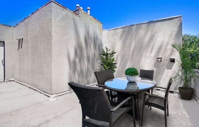 a patio with a table and chairs and a wall with a door