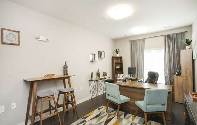 a home office with a desk and stools in front of a window