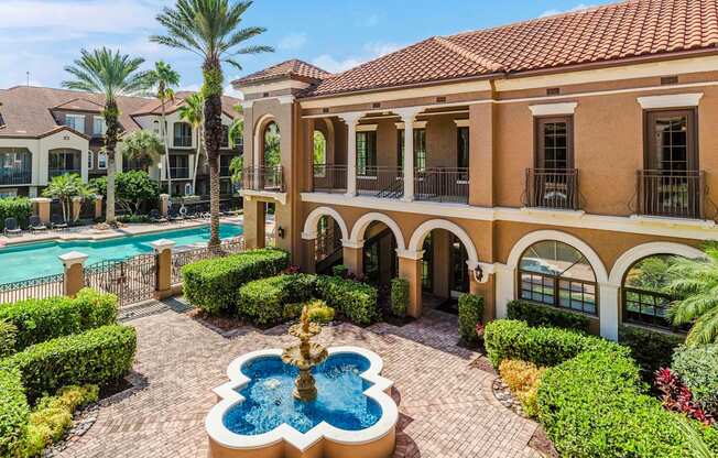 Resort-style courtyard with fountain and pool views surrounded by manicured landscaping.