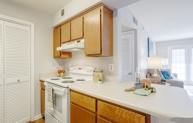 kitchen with white appliances and white countertops with light cabinetry
