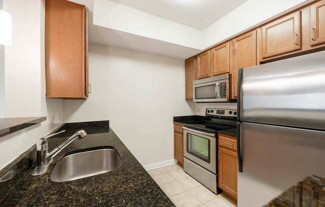 A kitchen with a stainless steel refrigerator, microwave, and oven.