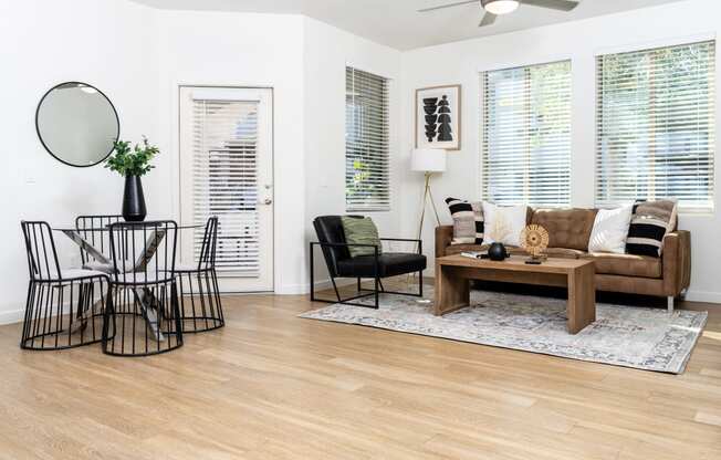 Living room and dining area with ceiling fan and balcony door
