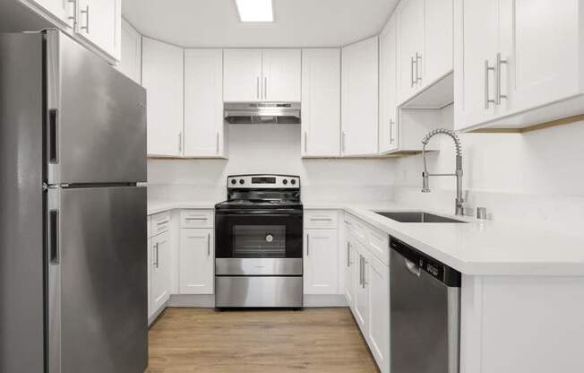 A modern kitchen with stainless steel appliances and white cabinets.