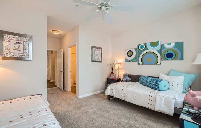 a bedroom with two beds and a ceiling fan