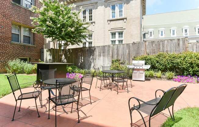 courtyard with table, chairs, grilling area and lush landscaping at meridian park apartments in washington dc