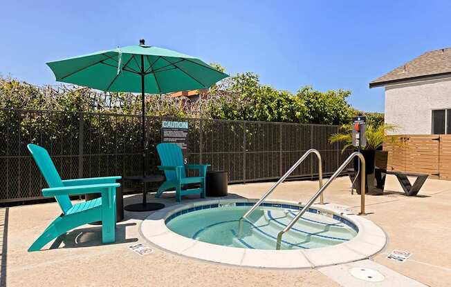 A small pool with a hot tub and two chairs.