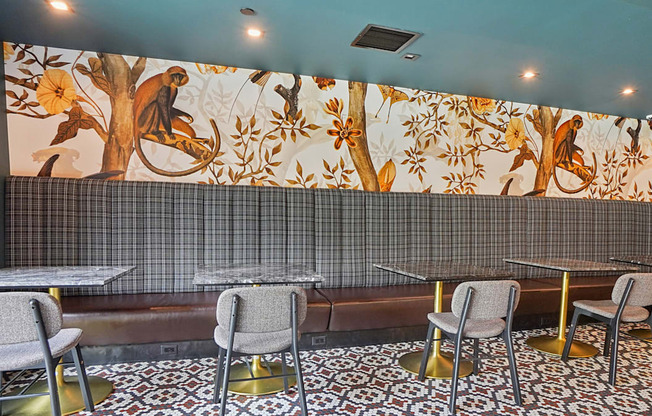 A restaurant with a blue wall and a mural of a tree with birds on it.