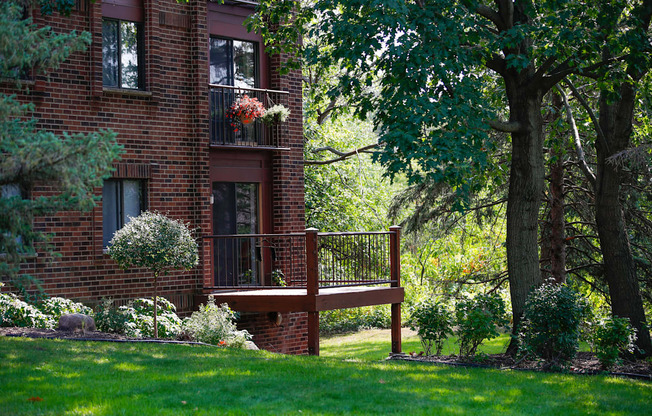 a wooden deck in front of a brick house