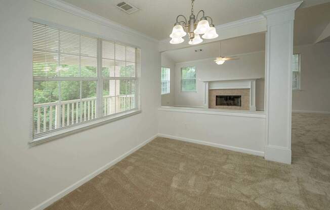 A room with a fireplace and a window with blinds.