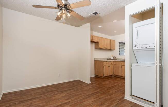 A room with a ceiling fan and wooden floors.