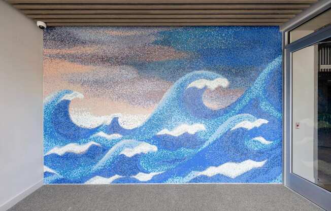 A painting of blue waves on a wall.