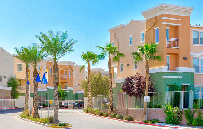 A row of palm trees in front of a building.
