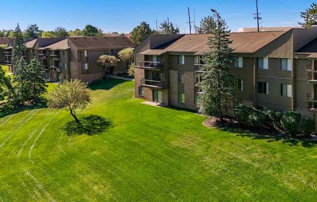 A large grassy area in front of apartment buildings.